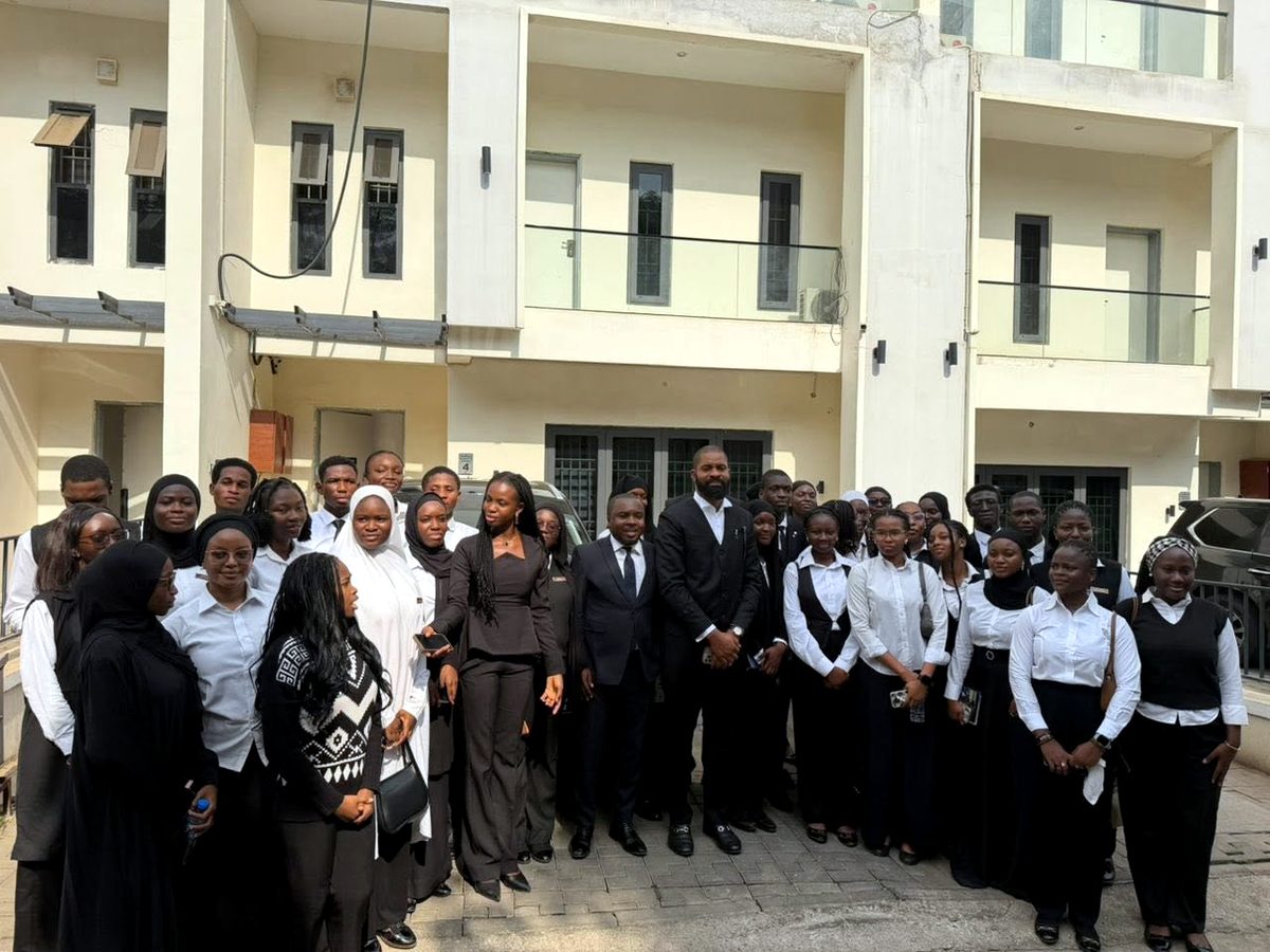 Deji Adeyanju with a large group of students outside a building in Abuja